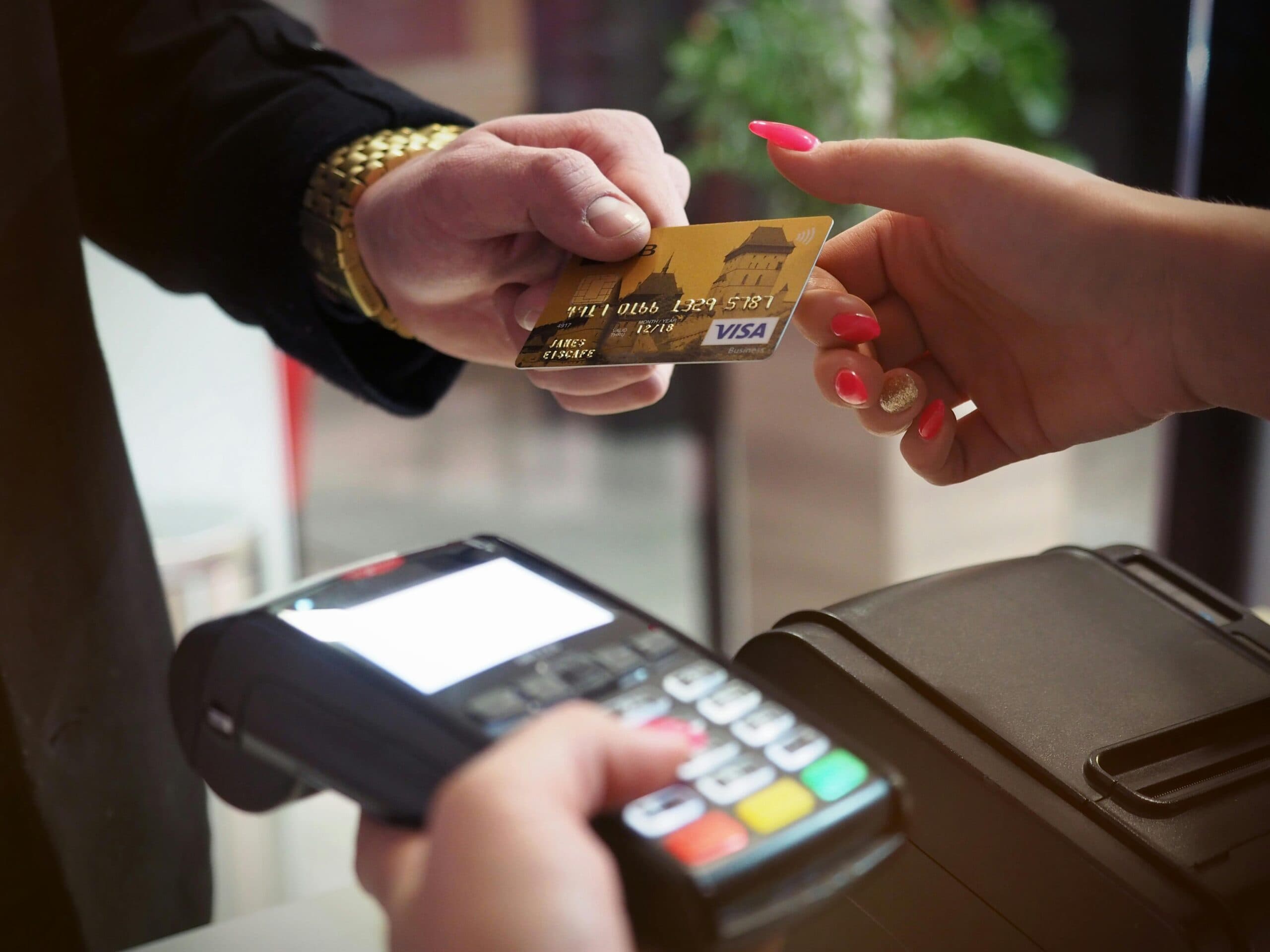 Retail image of customer handing credit card to sales person